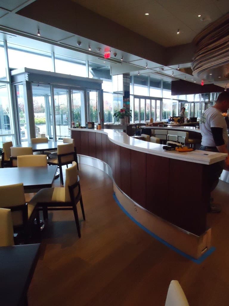 Curved custom wood bar with solid-surface top mid-install on a Deerfield Interiors jobsite, New York City